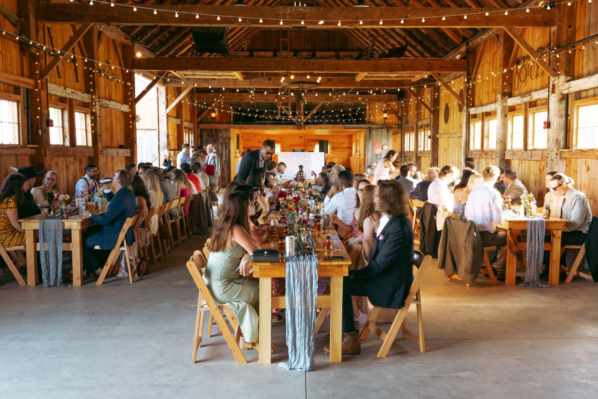 inside a wedding reception at the isham family farm barn in vermont