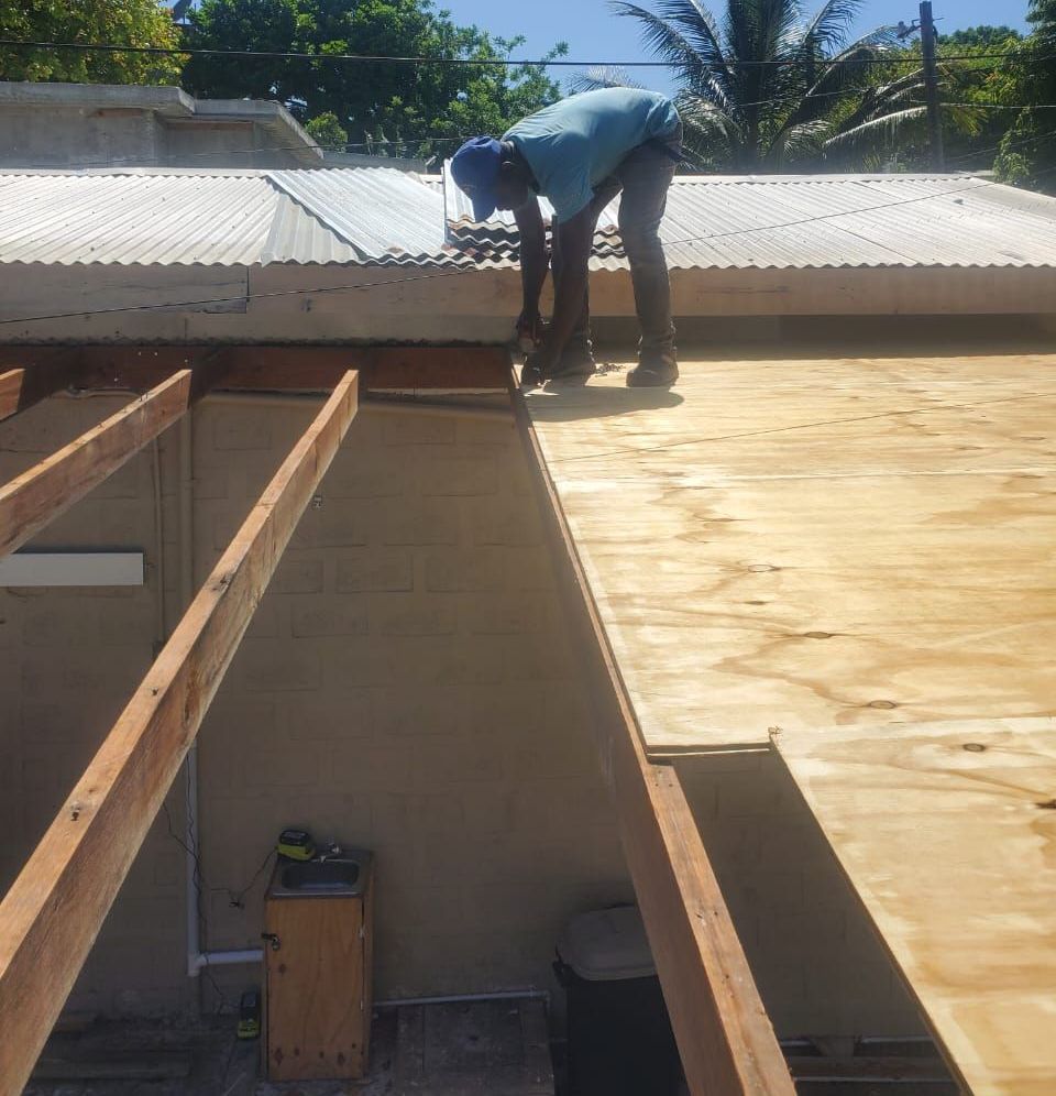 A man is working on the roof of a building
