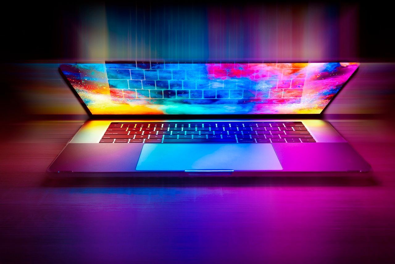 Laptop with a colorful, abstract display, glowing with neon hues.