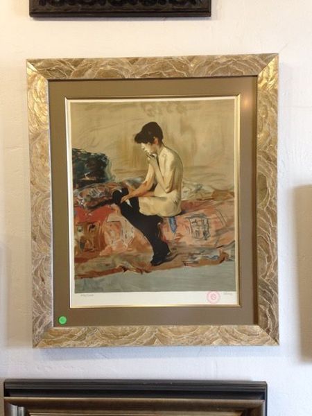 Framed painting of a seated person in beige, displayed on a wall above a radiator
