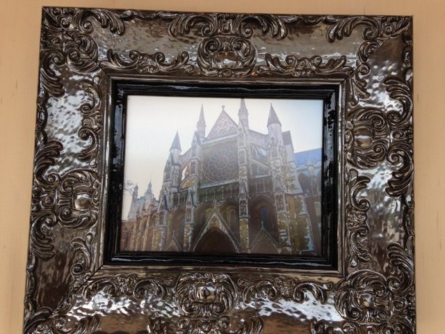 Ornate dark frame around a photo of a cathedral with pointed spires
