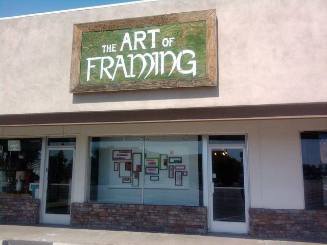 Storefront sign reading “The Art of Framing” above glass windows and doors.