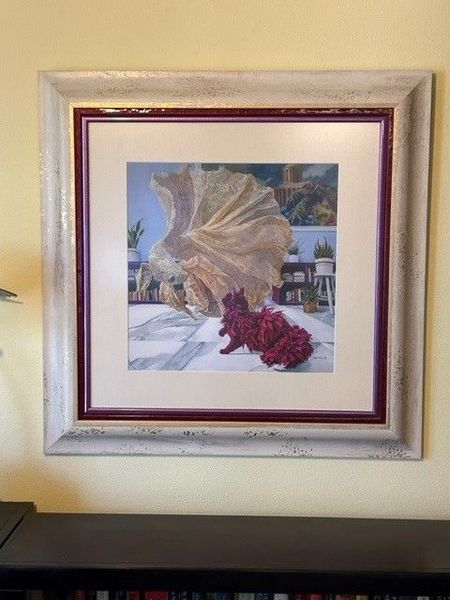 Framed artwork of a beach scene with a seashell and red starfish on a wall