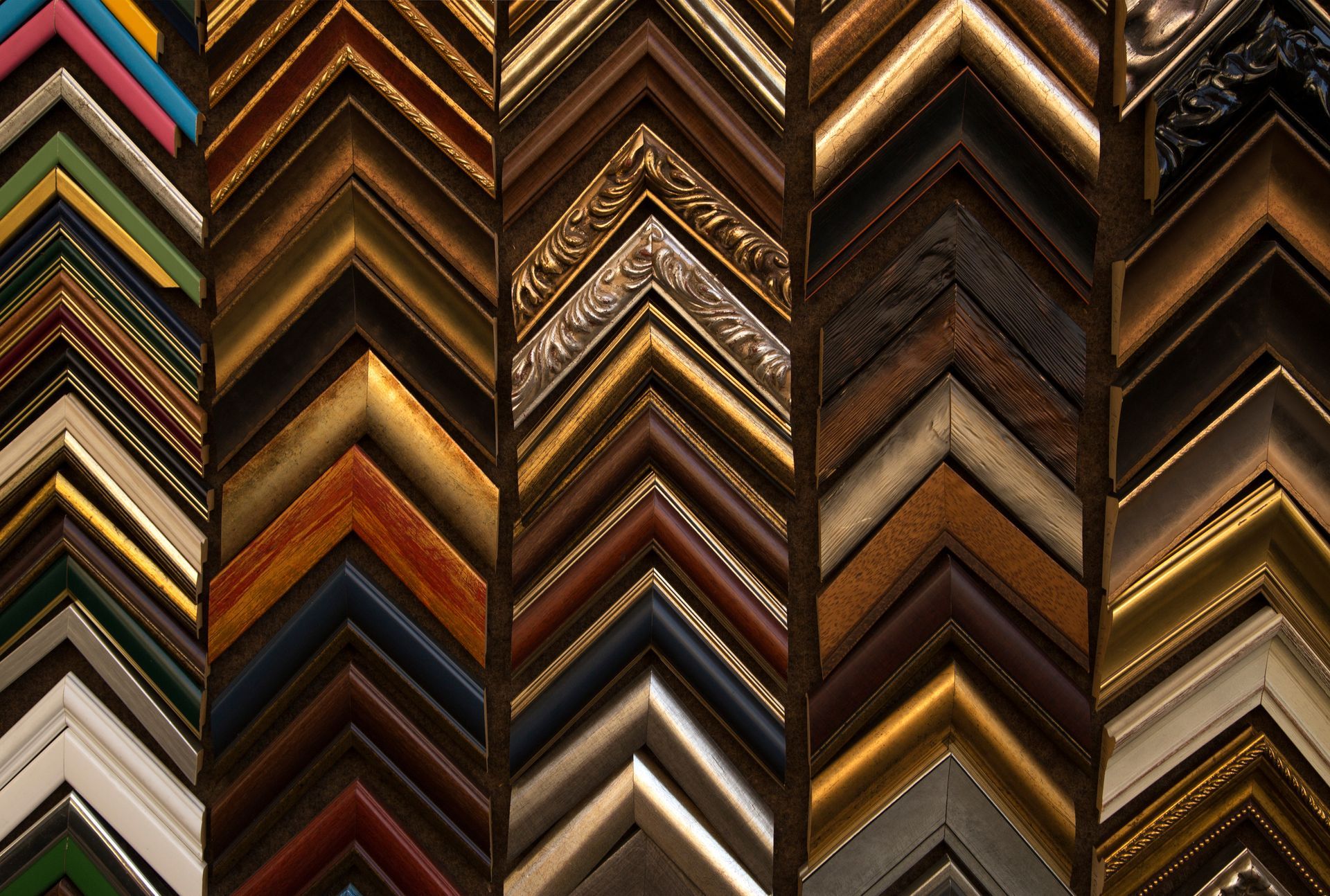 Rows of colorful zigzag picture frame corners in assorted wood and metallic finishes