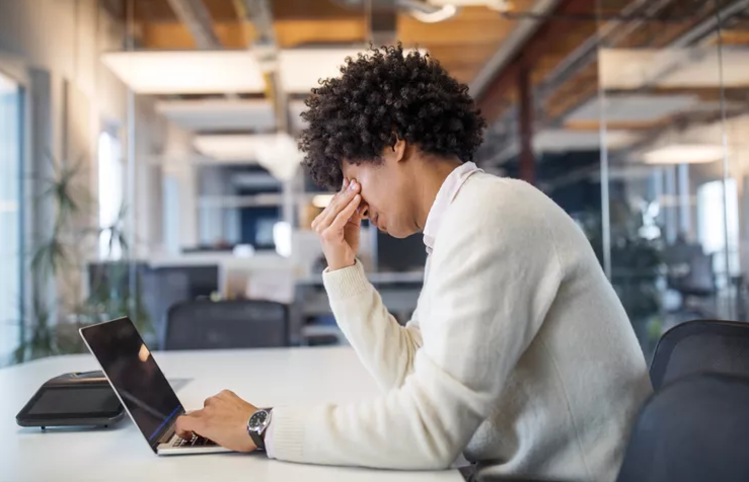 Stressed professional holding face while working long hours, showing link between job stress and depression in Albuquerque.