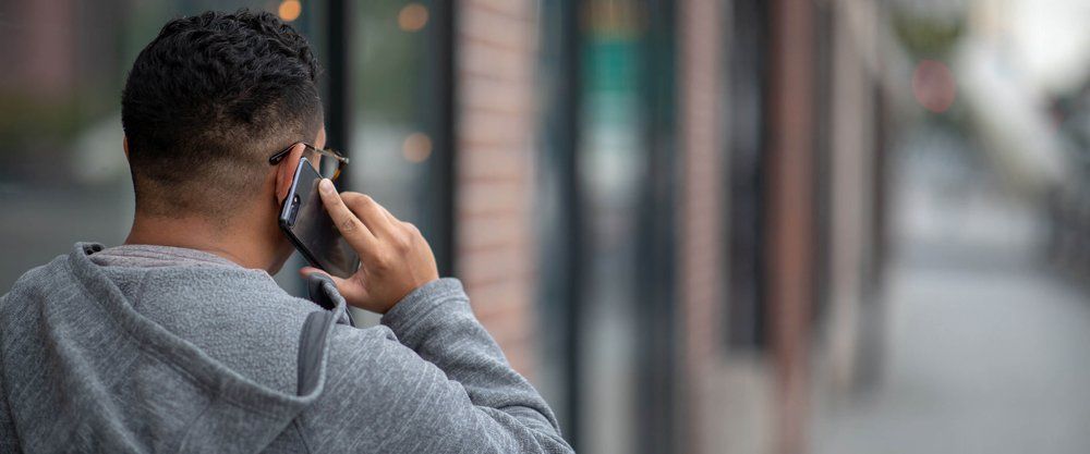 Man on a mobile phone seeking mental health support through the 988 hotline.