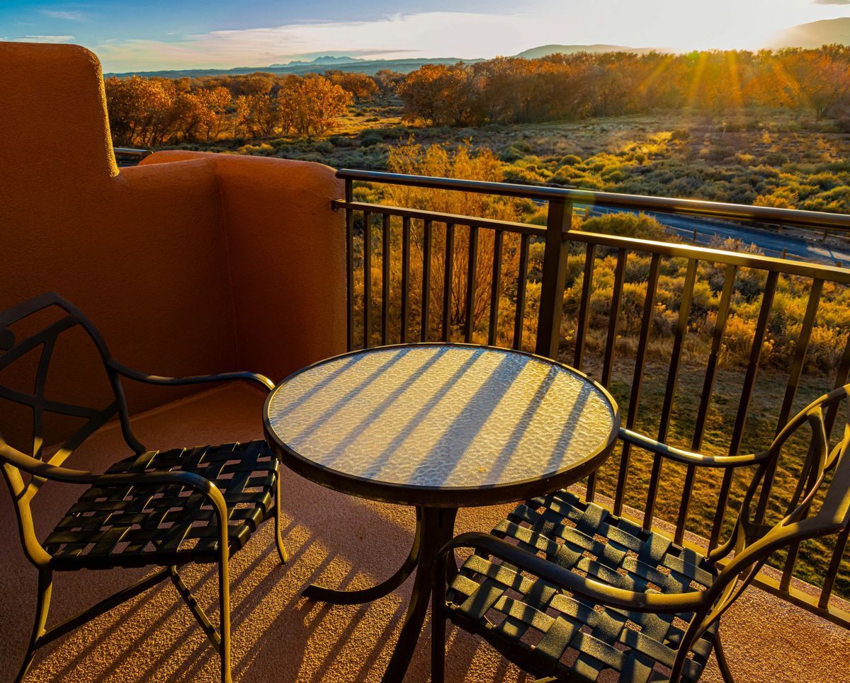 Scenic New Mexico sunrise view from a balcony with table and chairs, symbolizing calm morning routine
