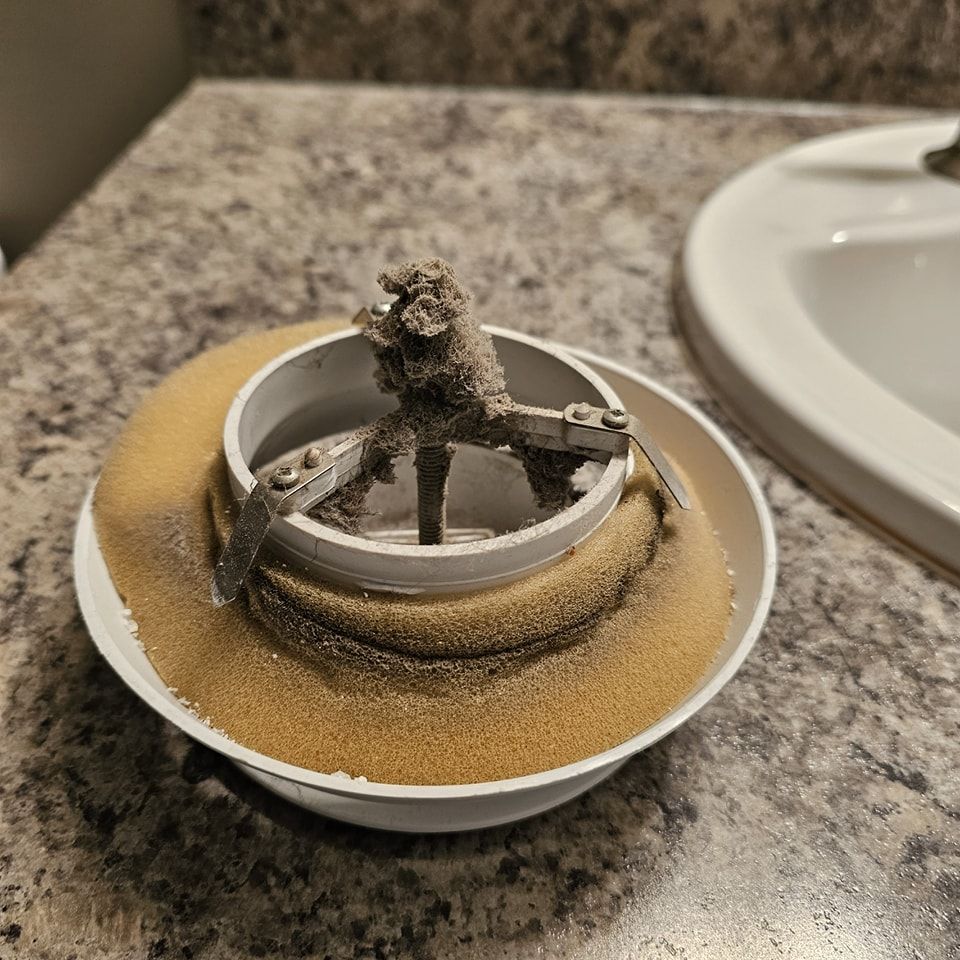 A bowl of sand is sitting on a counter next to a sink.