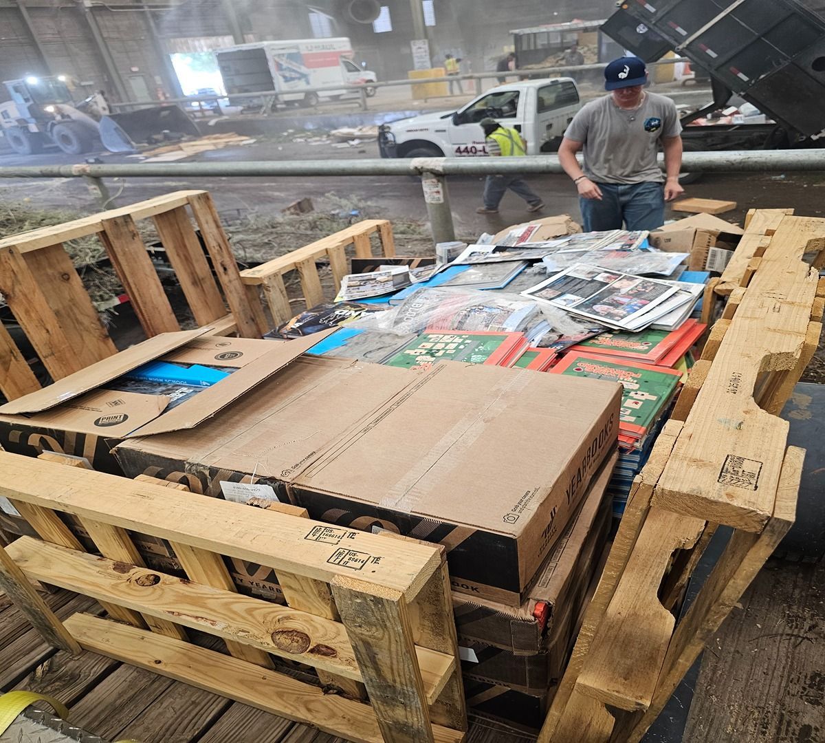 Large wooden crate of packaged goods in a wet warehouse, with a worker standing nearby