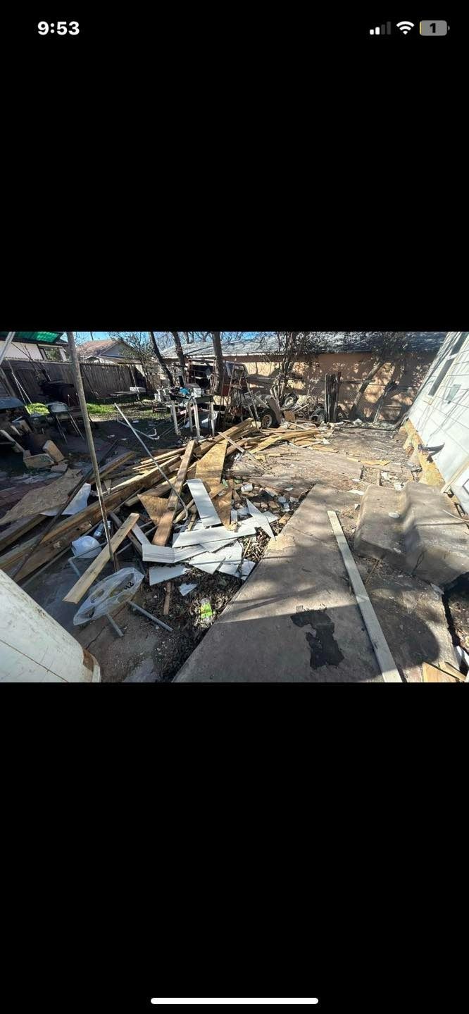 Debris-filled outdoor area with damaged structures, wood, and concrete.