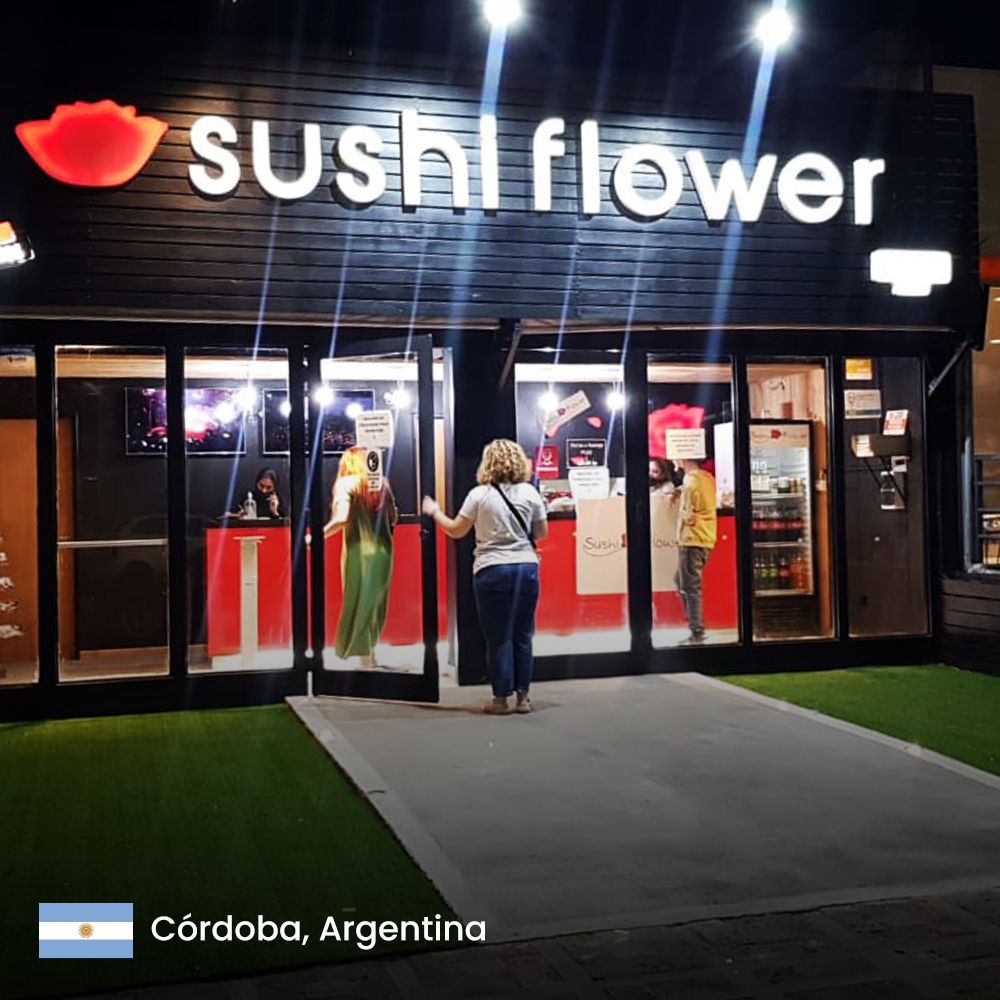 una mujer entra a una tienda de sushi por la noche