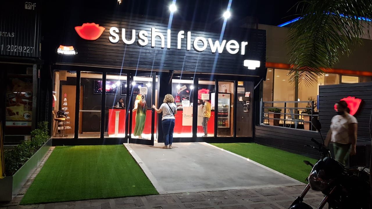 un restaurante llamado sushi flower se encuentra al lado de la carretera