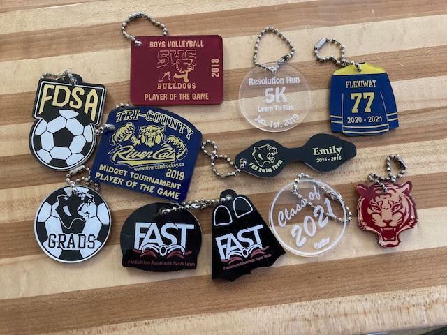 A bunch of keychains on a wooden table with one that says fast