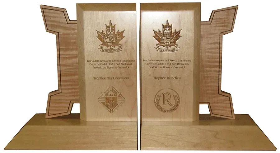 A pair of wooden bookends with a maple leaf on them