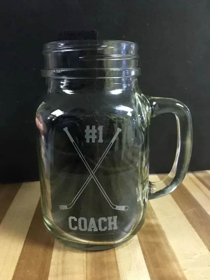 A mason jar with a hockey design on it is sitting on a wooden table.