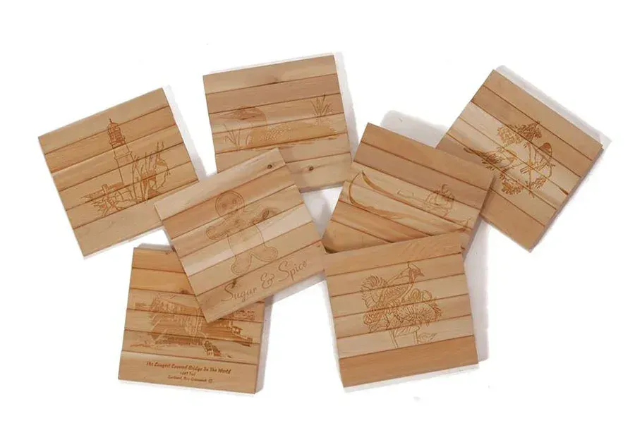 A group of wooden coasters are stacked on top of each other on a white surface.