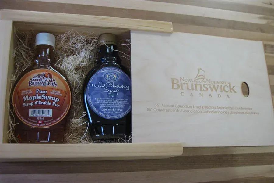 Two bottles of maple syrup in a wooden box from brunswick canada