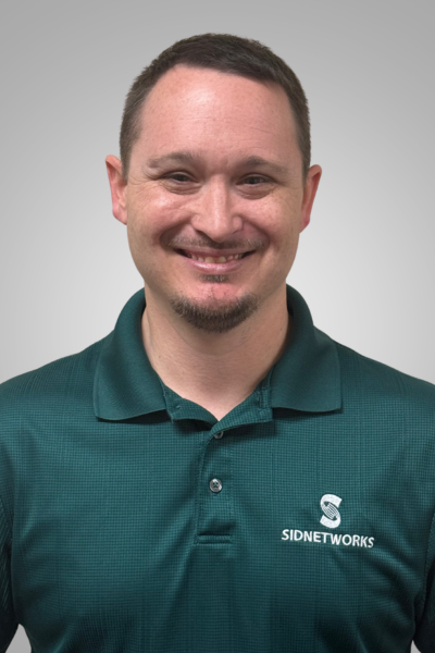 Man smiling, wearing a green polo shirt with 
