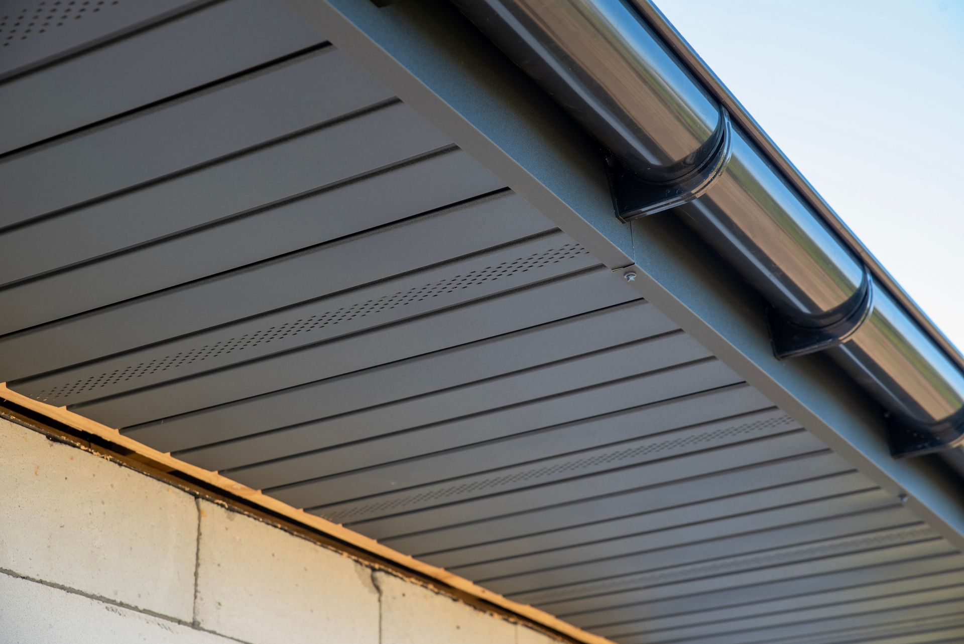 Metallic soffit and plastic gutters blend modern design. Metallic soffit and plastic gutters blend modern design.