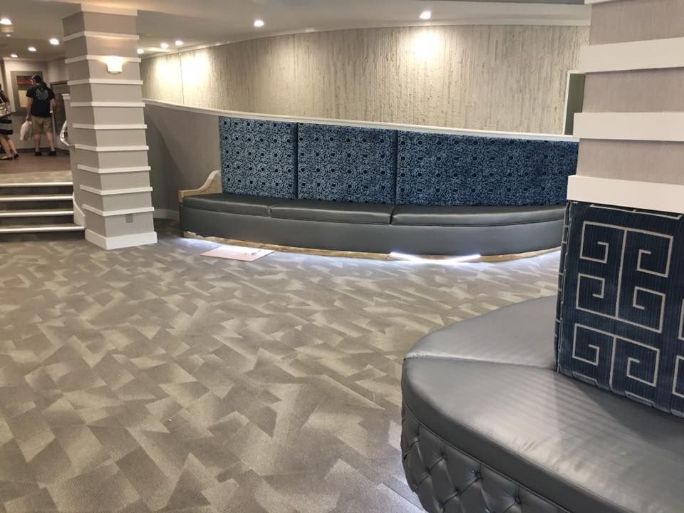 Modern hotel lobby with blue patterned benches, gray floor, and striped columns