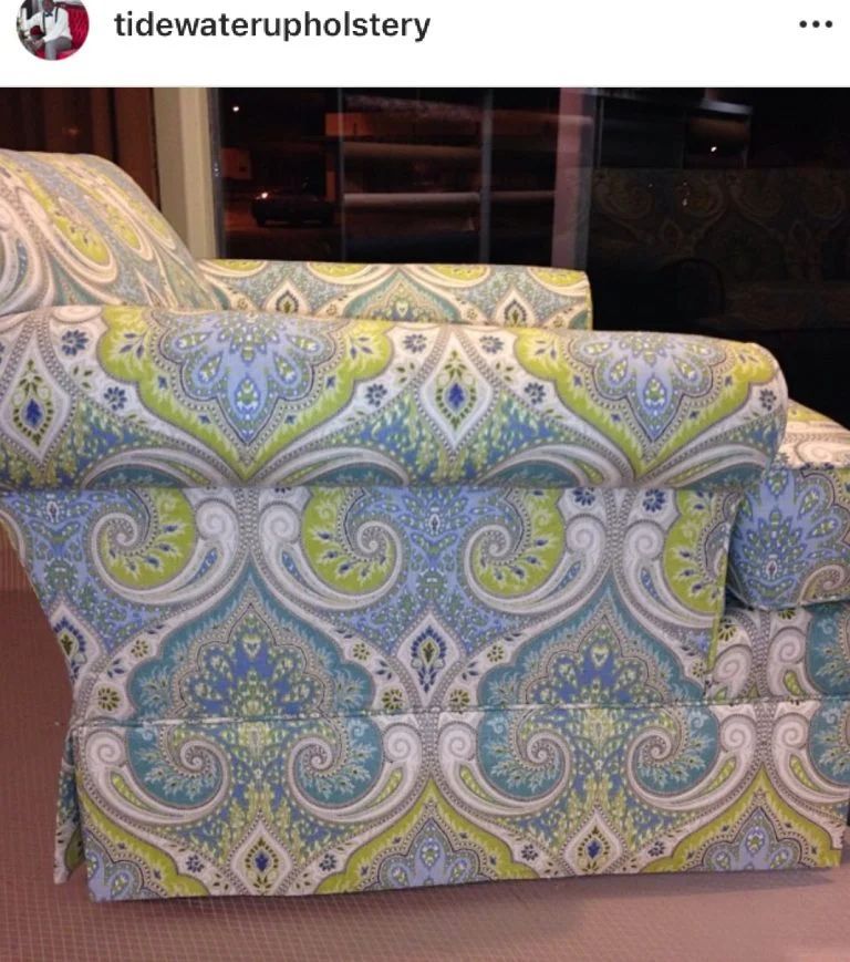 Paisley-patterned upholstered armchair in blue, green, and cream with a matching cushion
