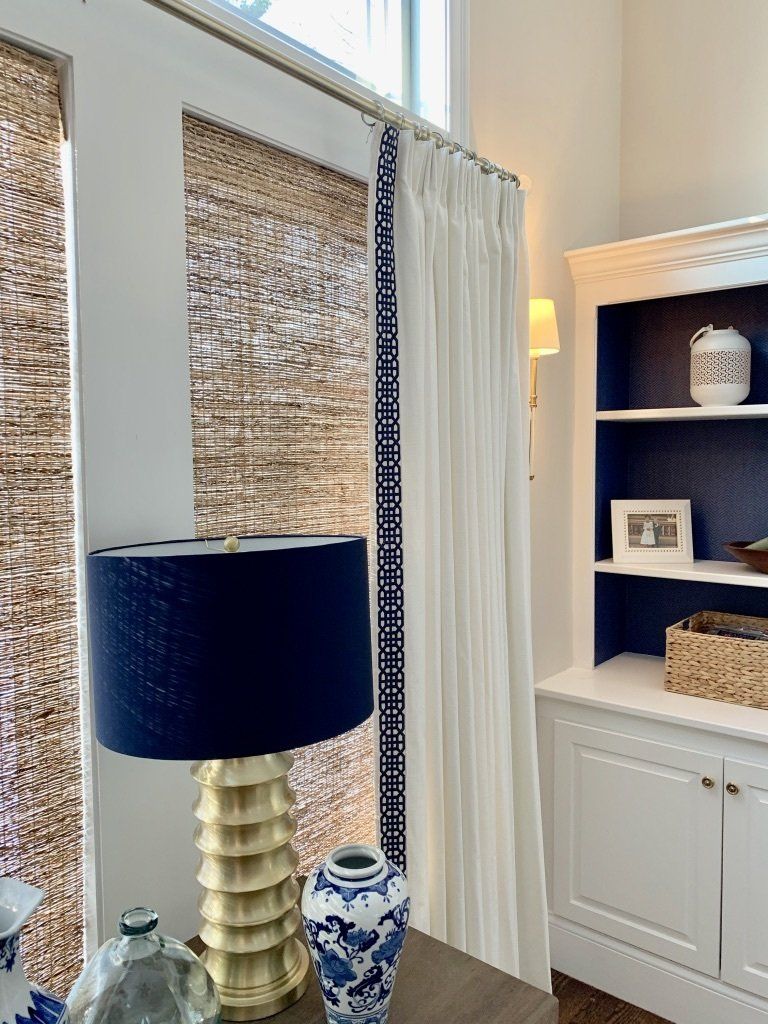 Room corner with a blue lamp, white curtains, and a built-in blue and white bookcase.