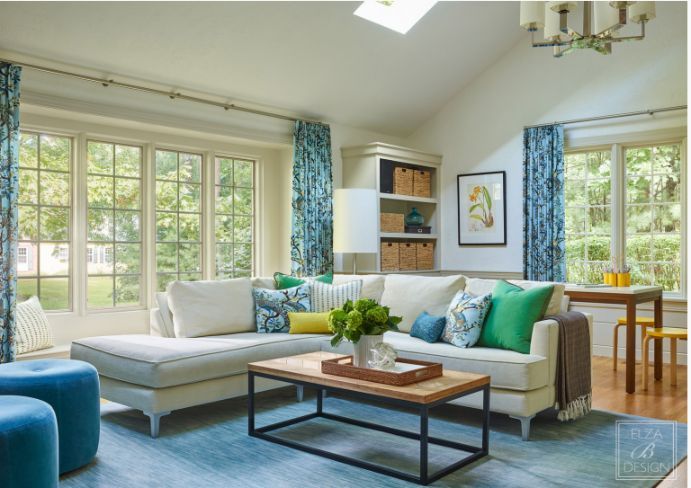 a living room with a sectional couch and a coffee table and drapery with designer fabrics and textiles Simply Windows