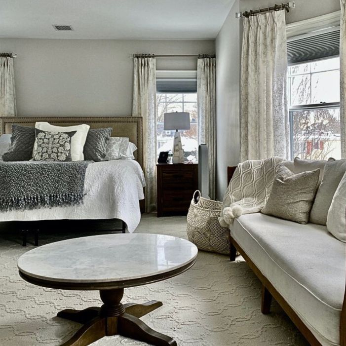 a bedroom with a bed , couch , coffee table and window with designer fabrics and textiles window treatments Simply Windows.