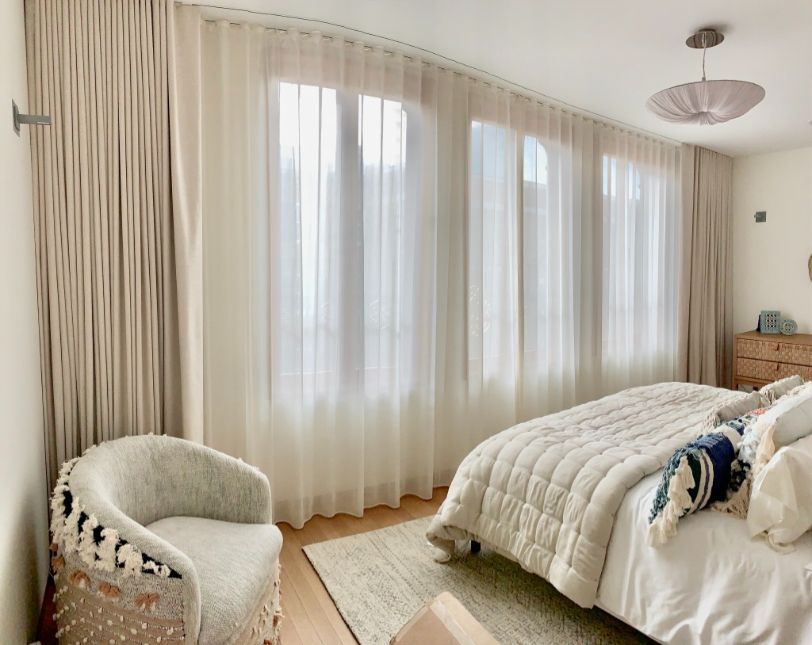 a bedroom with a bed , chair and draperies made from designer fabrics and textiles Simply Windows