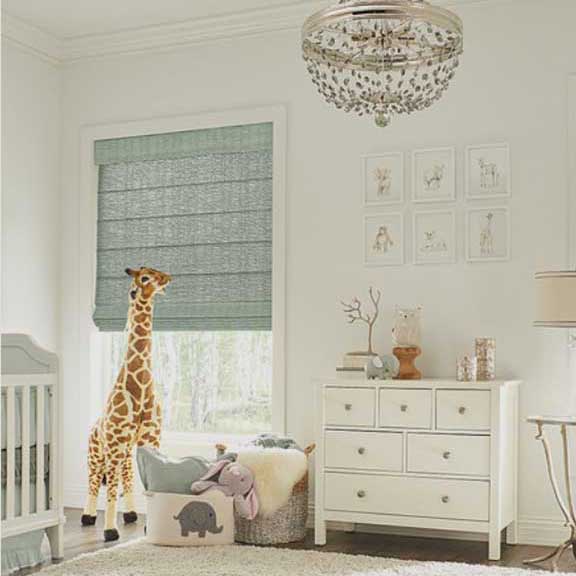 a room with a crib a dresser and a stuffed giraffe and roman shades on the windows Simply Windows