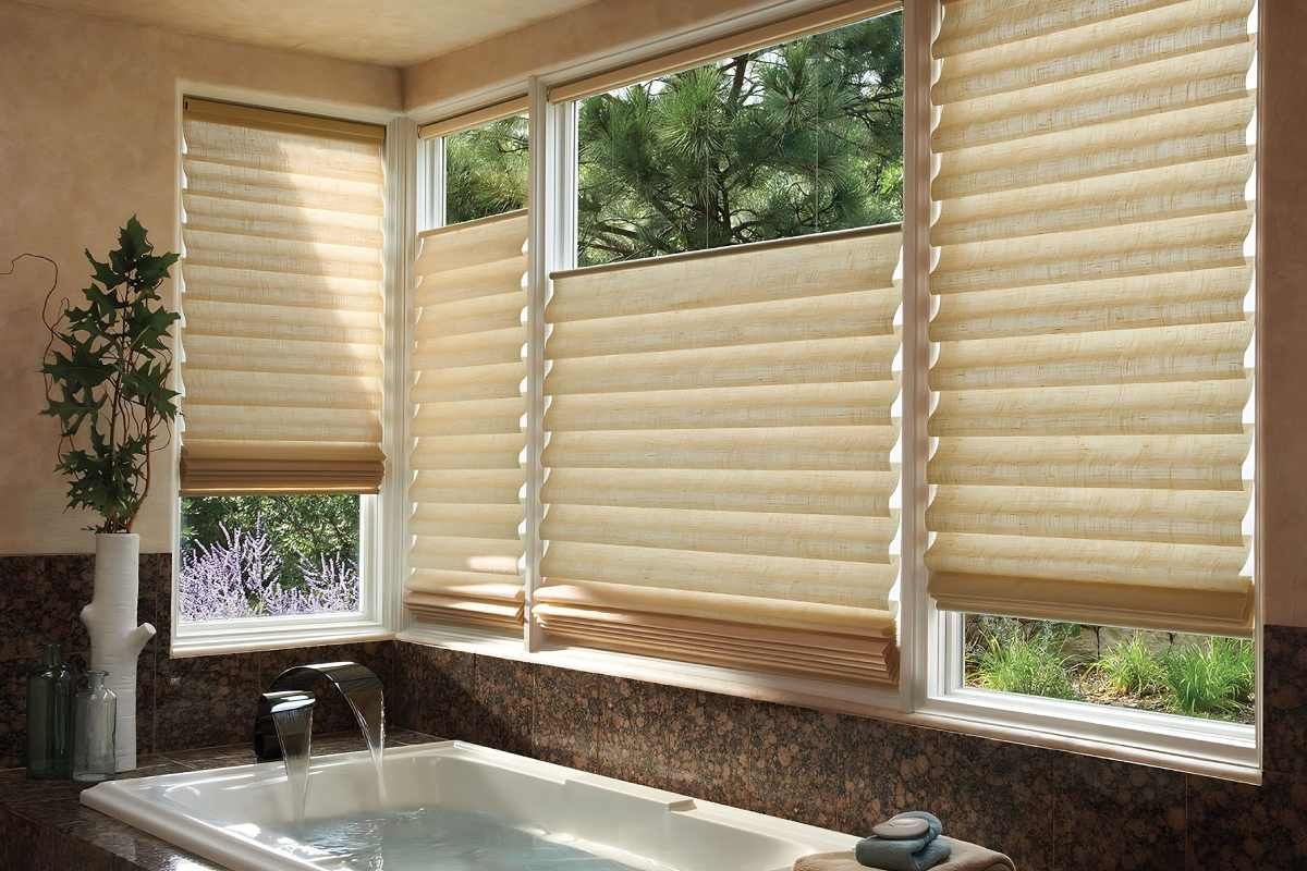 a bathroom with a bathtub and a window with roman shades Simply Windows