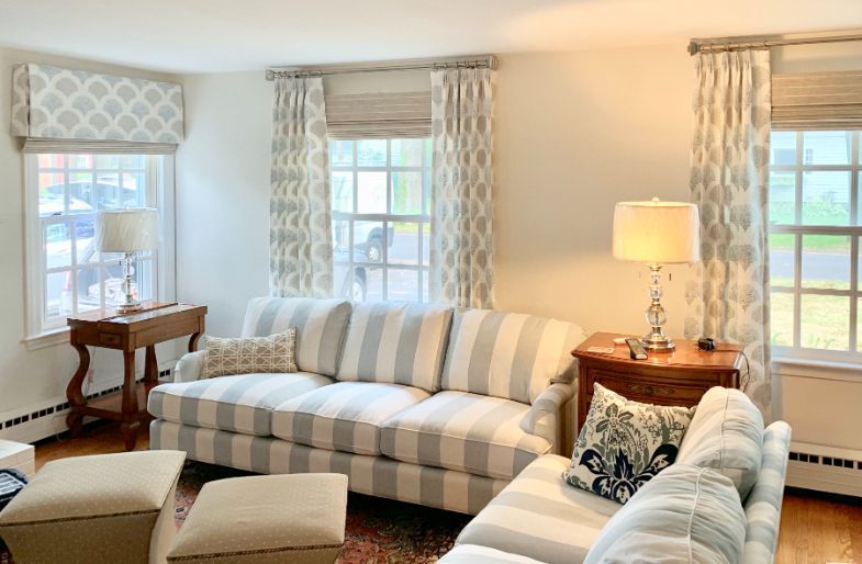 Living room with striped sofa, patterned curtains, and neutral decor.