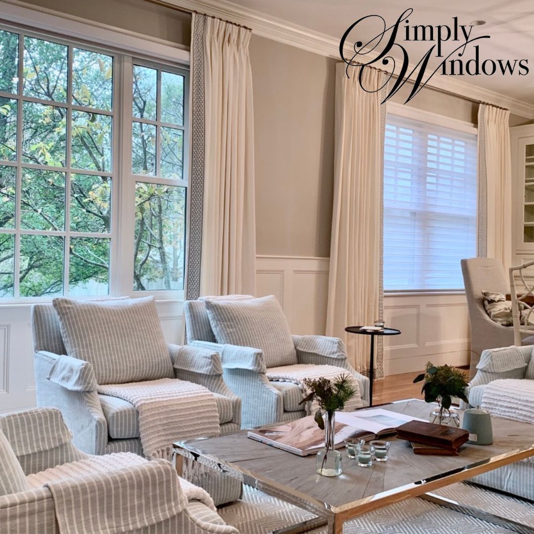 Bright, cozy living room with cream furniture and large windows with custom window treatments.