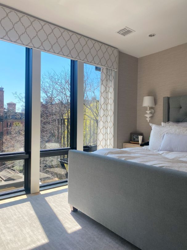 a bedroom with a large bed and lots of windows with elite window treatments Simply Windows