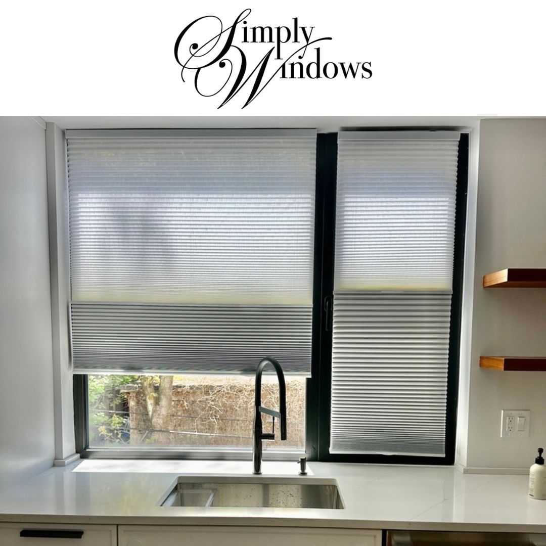 Kitchen window with white blinds, a stainless steel sink, and black faucet.
