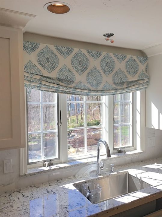 a kitchen with a sink and a window with roman shades made from designer fabric Simply Windows