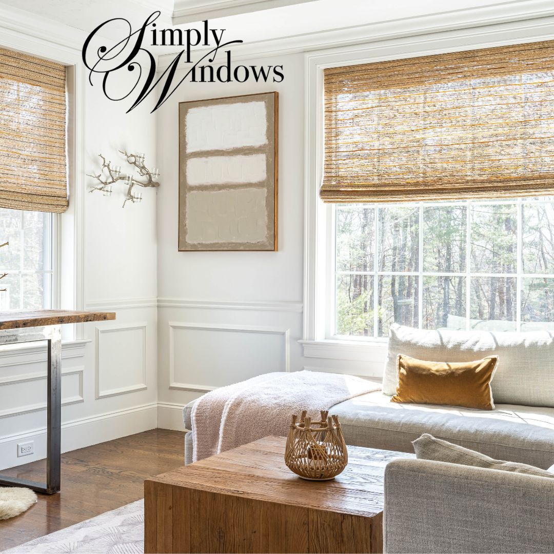 Bright living room with woven roman shades, white walls, a window seat, and a wooden coffee table