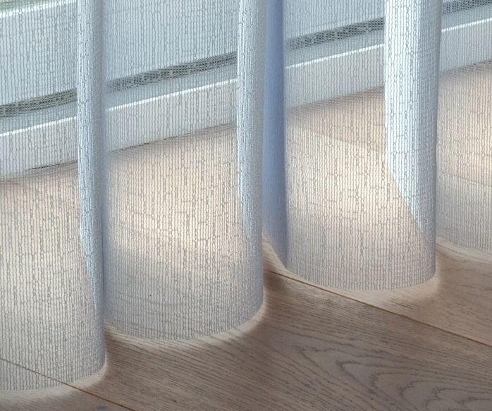 Sheer white curtains partially obscuring a window, casting shadows on a wooden floor.