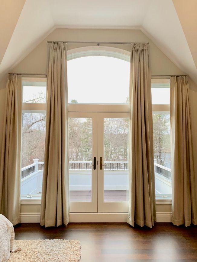 A bedroom with a large window and sliding glass doors