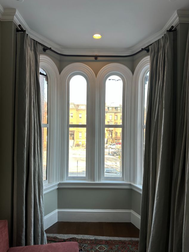 A living room with two arched windows and curtains.