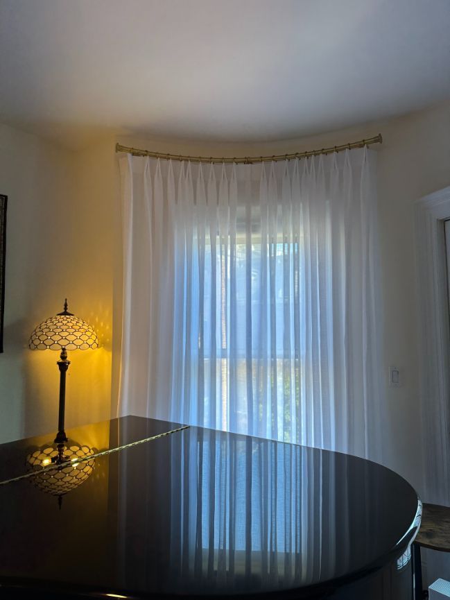 A living room with a piano and a lamp