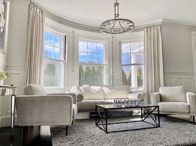 A living room with a couch , chairs , and a coffee table.