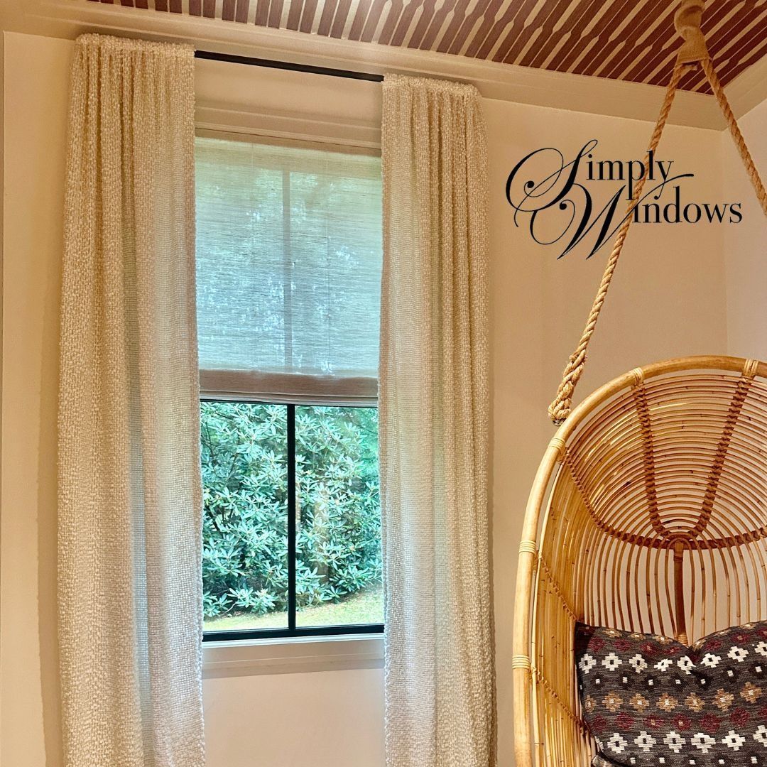 Bright room with sheer shades, drapery, a window, and a hanging wicker chair by a wall logo.