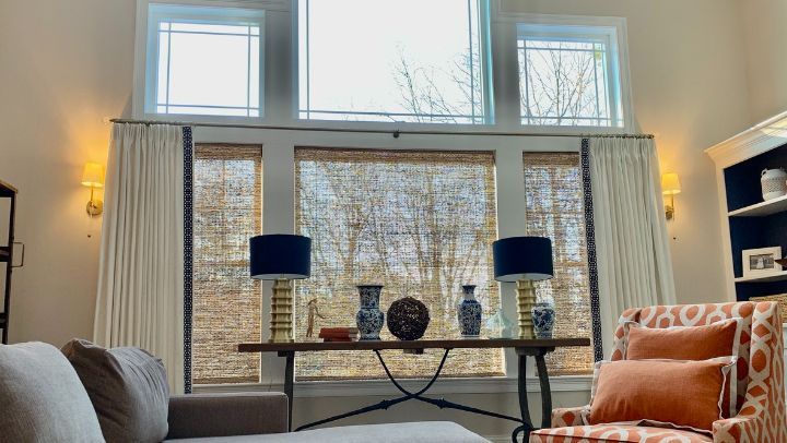 Simply Windows: A living room with a couch , chair , table and woven wood shades on the windows.