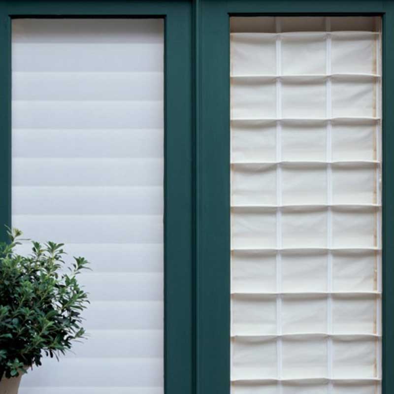 a window with a plant in front of it and roman shades Simply Windows