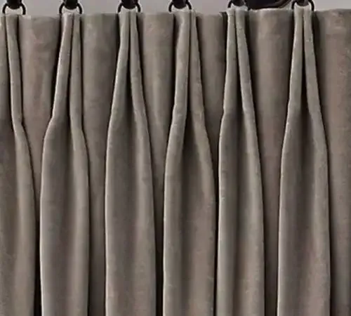 Gray pleated curtains hanging from a curtain rod