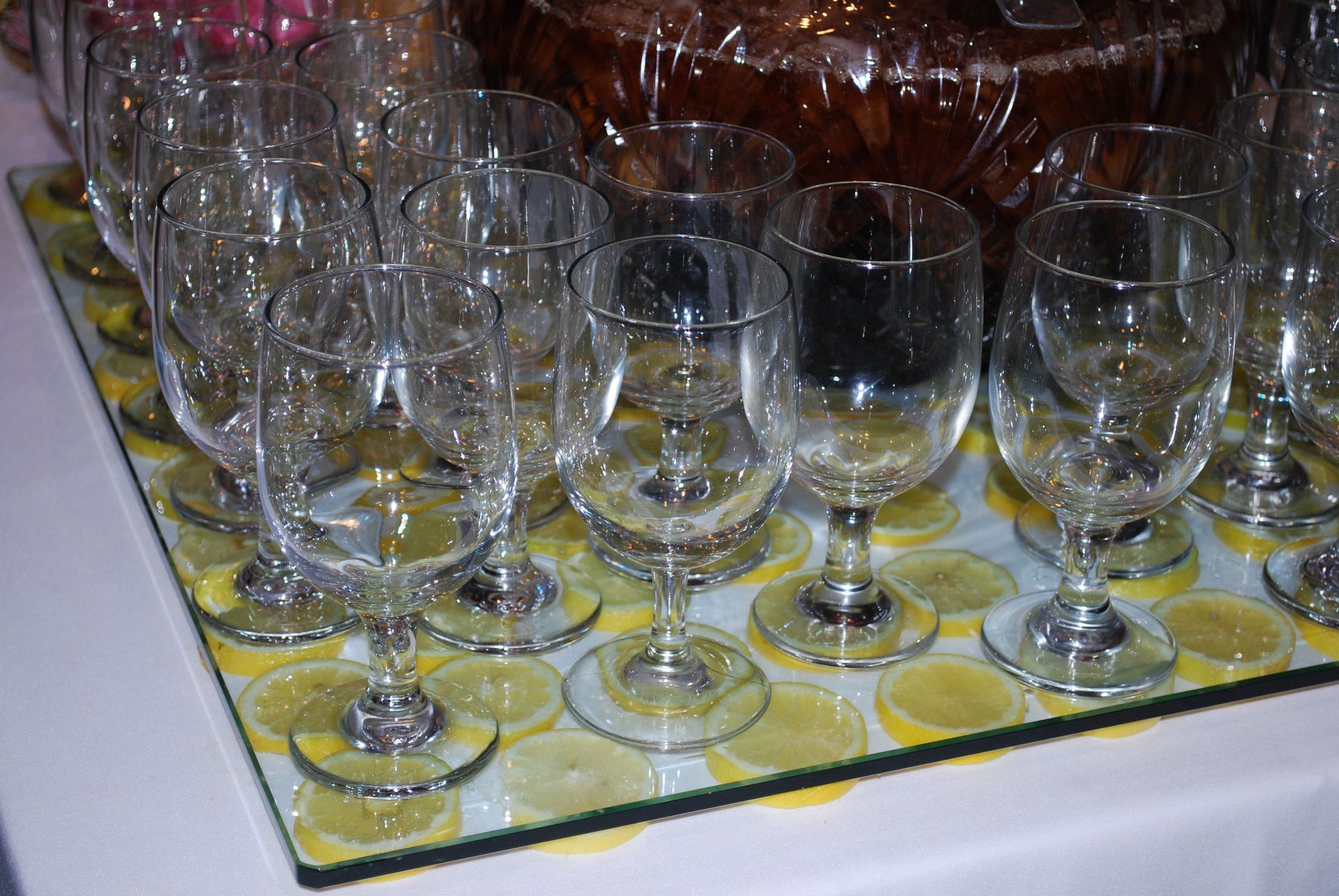 Rows of empty wine glasses on a table with a yellow patterned cloth