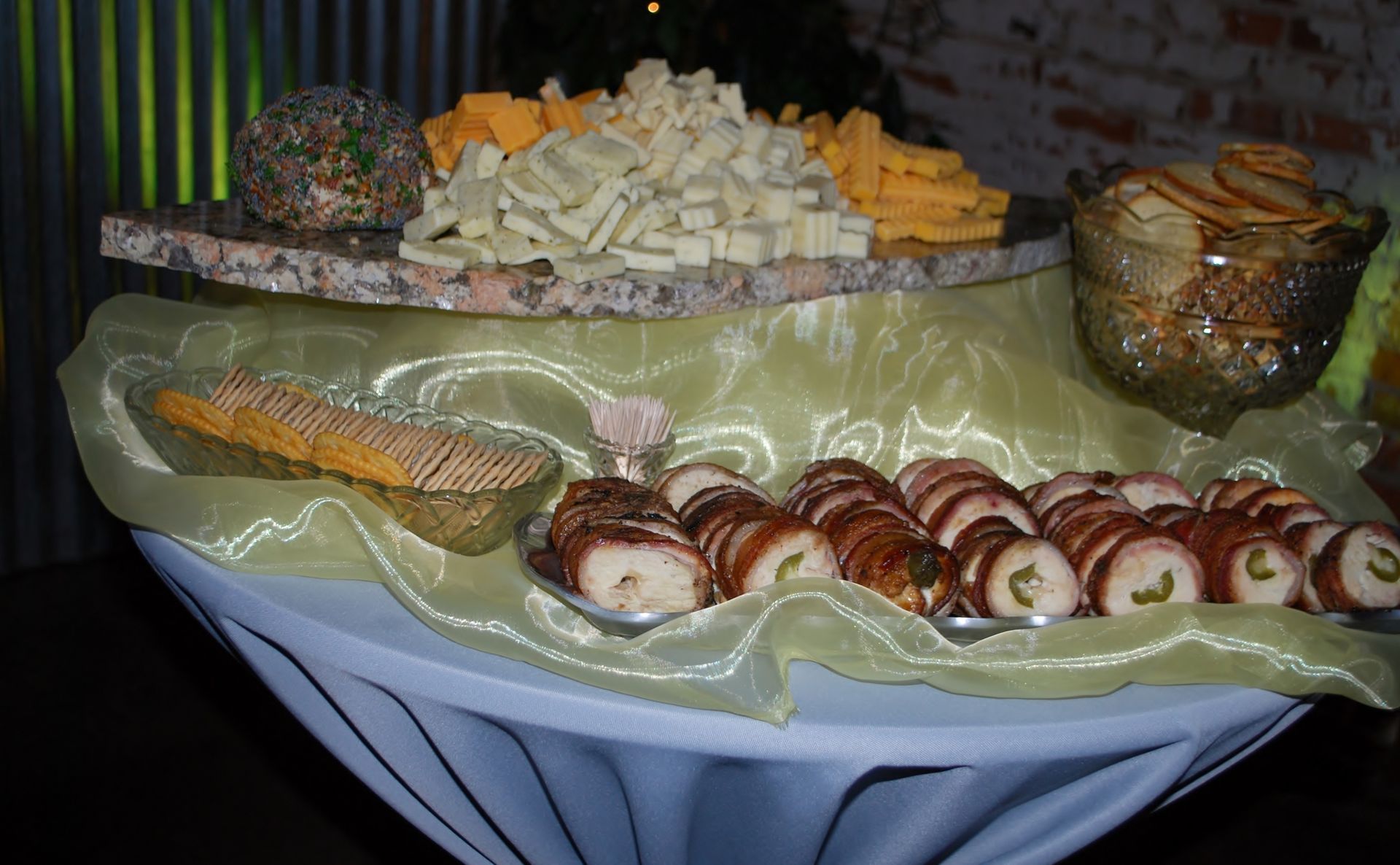 Assorted pastries and cookies arranged on a table with a green cloth and napkin holder at a buffet.