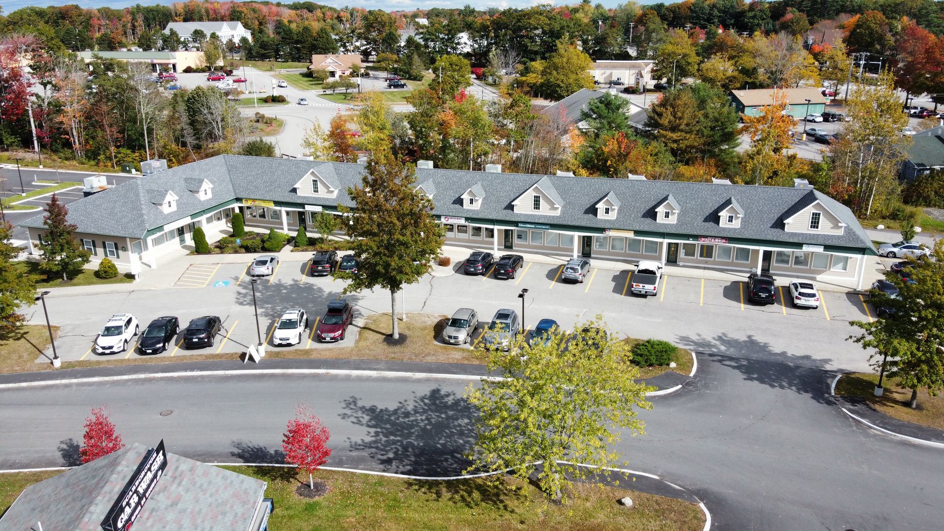 an aerial view of a building with a lot of cars parked in front of it .