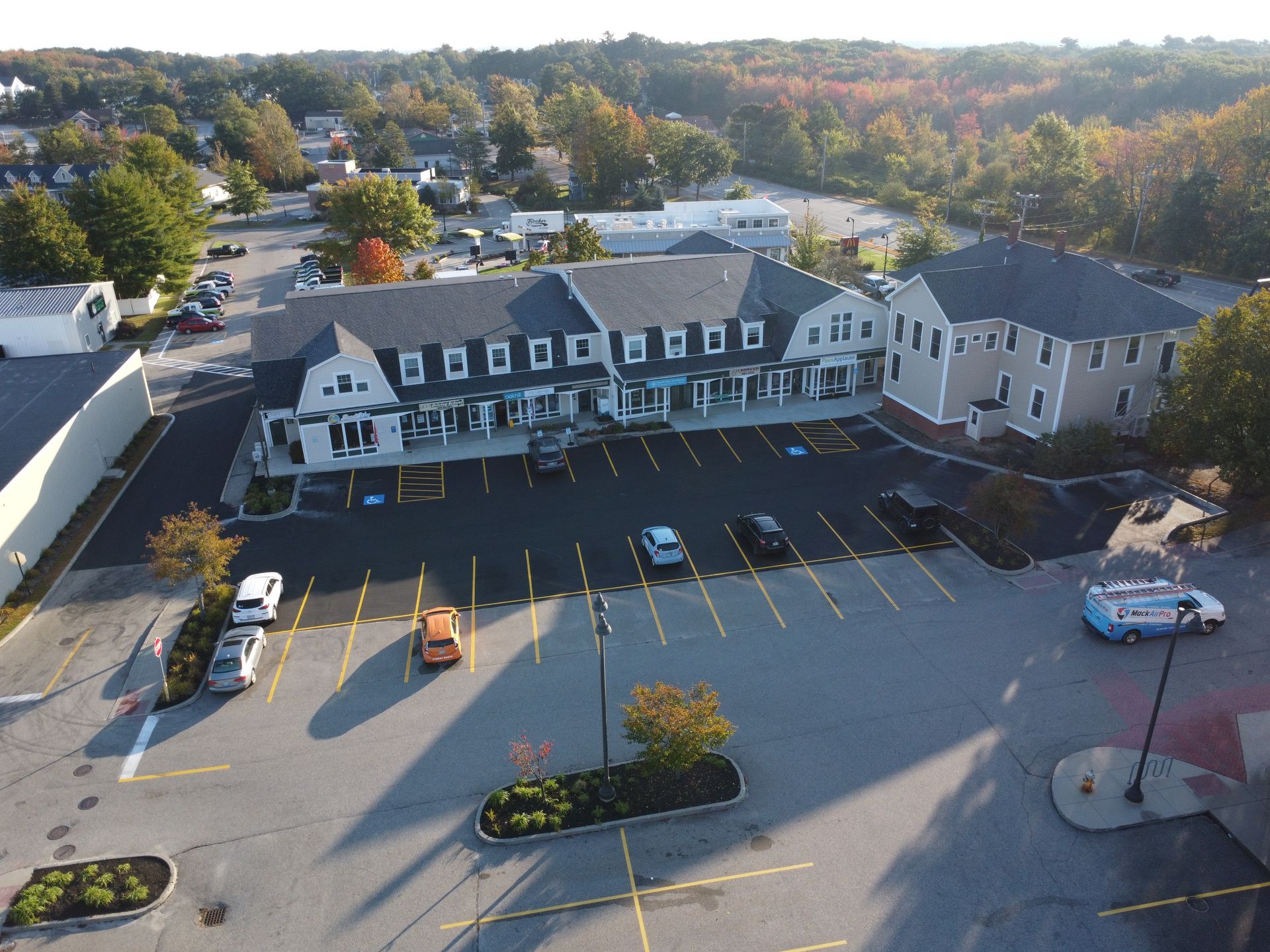 an aerial view of a parking lot with a building in the background